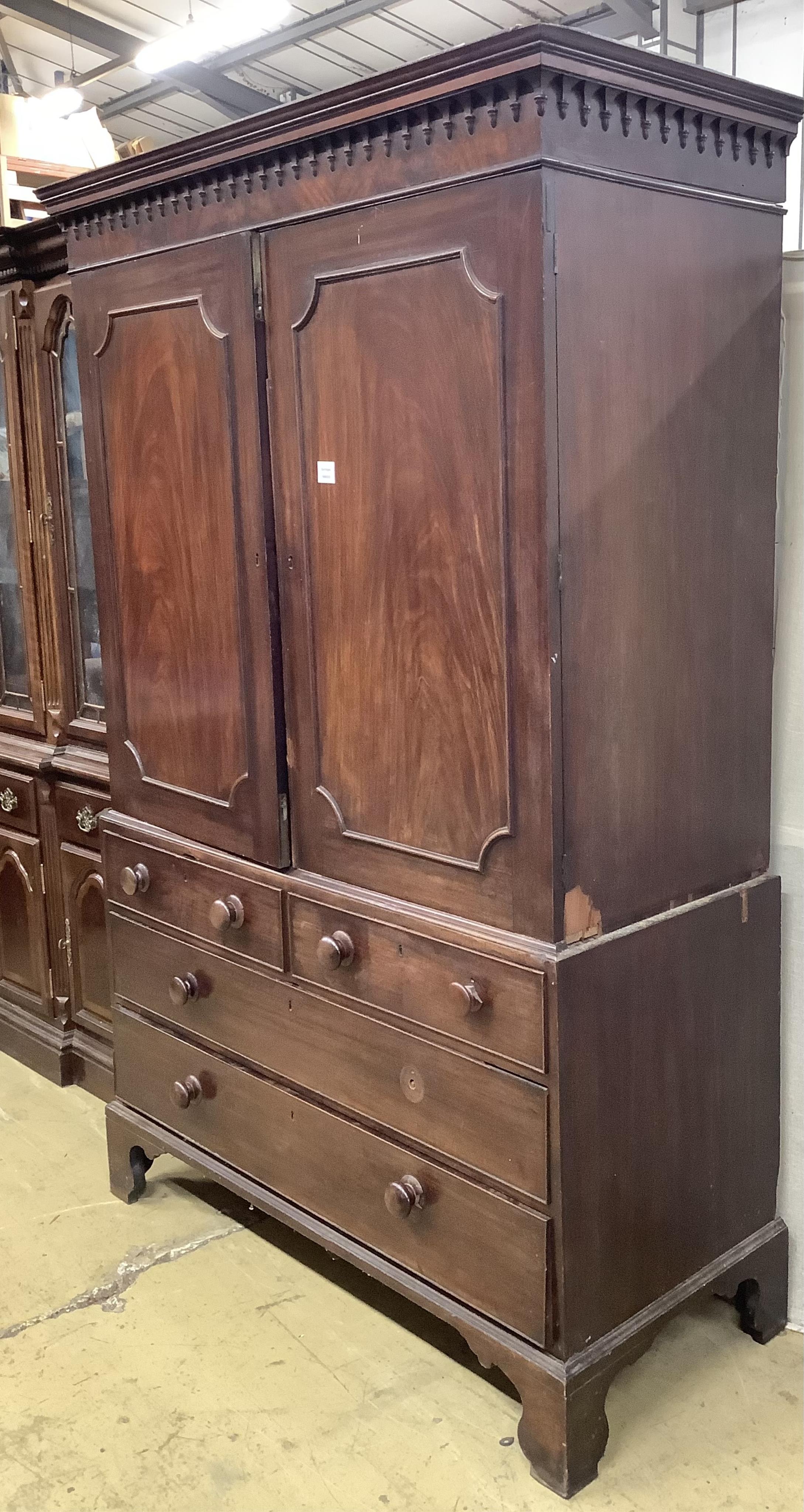 A George III mahogany linen press, the top retaining the original sliding trays, width 129cm, depth 56cm, height 201cm. Condition - poor